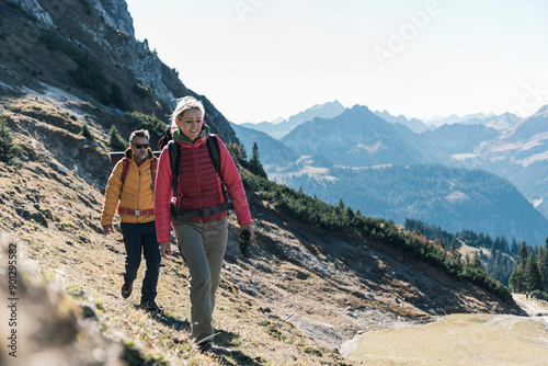 Mature woman hiking with friend on mountain photo