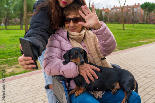 a girl taking photos with her grandmother in a wheelchair