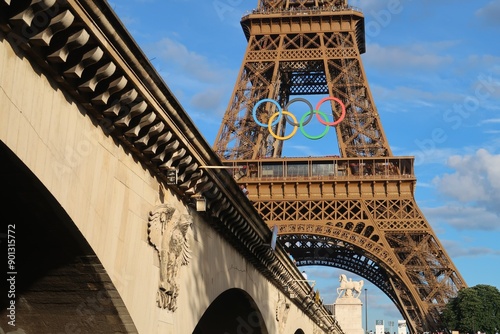 Vue sur les anneaux olympiques, célèbre logo symbole des Jeux olympiques, ornant la tour Eiffel pour les JO d’été de Paris 2024, avec le pont d’Iéna au premier plan – juillet 2024 (France)