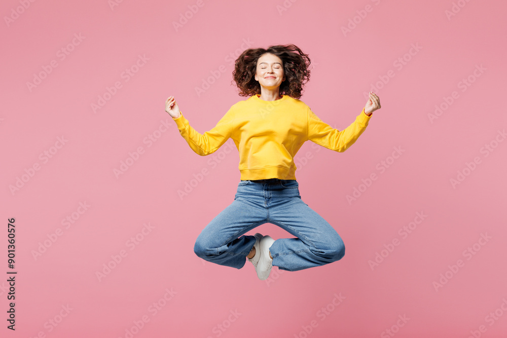 Full body young shocked surprised woman wearing yellow sweatshirt casual clothes jump high spread hands look camera isolated on plain pastel light pink background studio portrait. Lifestyle concept. Full body young shocked surprised woman wearing yellow sweatshirt casual clothes jump high spread hands look camera isolated on plain pastel light pink background studio portrait. Lifestyle concept.