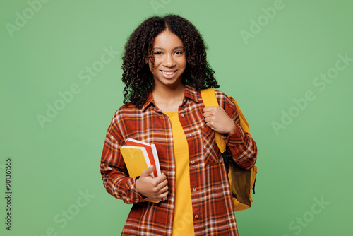 Fényképezés Young smiling happy cheerful smart freshman teen girl student wear brown yellow casual clothes backpack bag hold books isolated on plain green color background