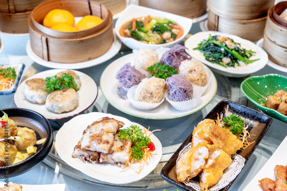 Image of various Chinese dim sum in a bamboo steamer, equipped with chopsticks and tea, on a wooden table. Image of various Chinese dim sum in a bamboo steamer, equipped with chopsticks and tea, on a wooden table.