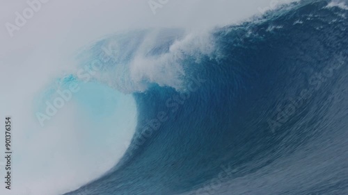 Slow motion barreling wave with crystal clear blue turquoise texture and wind spray whitewash photo