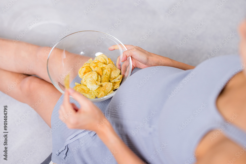 Obraz premium Pregnant woman eat potato chip