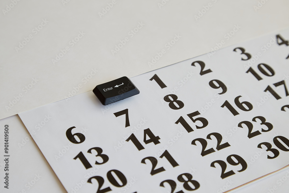 Obraz premium Enter key from a computer keyboard on a calendar, start of the month, start of a project, start of work, time management, and deadlines