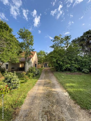 path in the countryside leads to village house