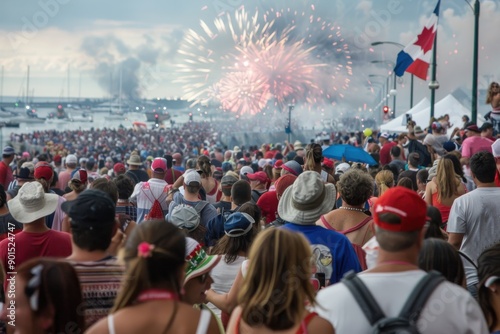 Wallpaper Mural A large crowd gathered at a waterfront celebrating with colorful fireworks, flags flying, and boats in the background, creating a lively and festive atmosphere. Torontodigital.ca