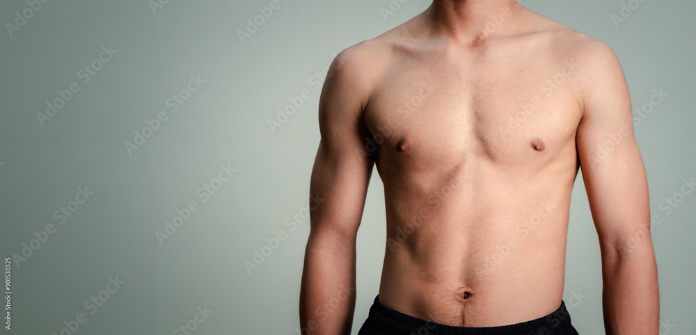 Handsome muscular young man posing against a grey background. male model taking off his shirt on a gray background, body transformation , weight loss, sixpack Handsome muscular young man posing against a grey background. male model taking off his shirt on a gray background, body transformation , weight loss, sixpack