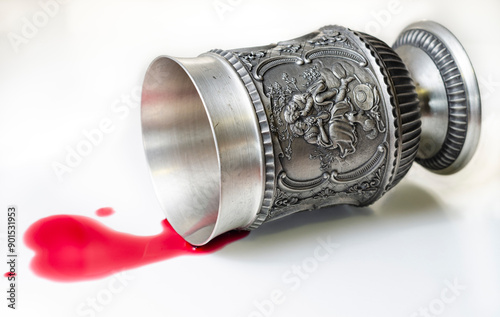 A goblet with a scene representing two lovers, overturned from which a heart-shaped stain of red wine flows. Betrayal, poisoning concept composition