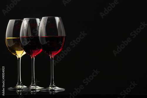 Set of wine glasses with red, white and rose wines on a black background. Concept template for advertising wineries, wine brand, restaurants and family with place for text