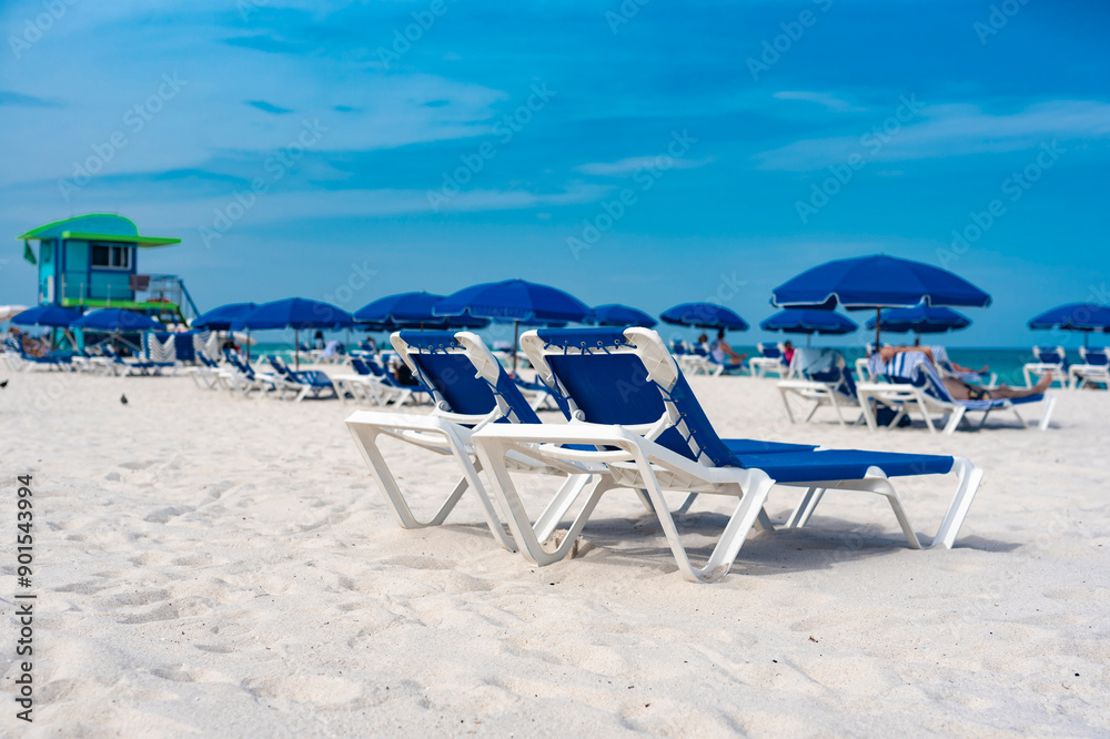 Blue parasols and chaise lounges facing the beach. At Miami Beach, Florida. Blue parasols and chaise lounges facing the beach. At Miami Beach, Florida.
