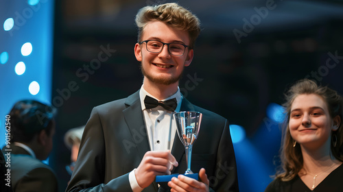 Young entrepreneur receiving an award for innovation at a tech conference gala event.