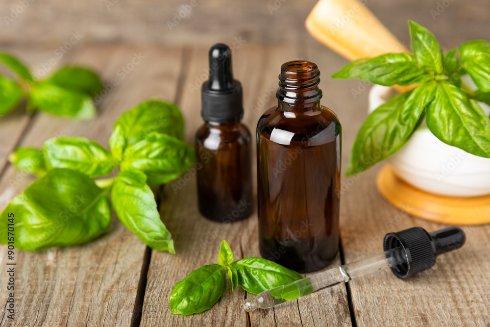 Basil essential oil on a textured wooden background. Basil essential oil and fresh leaves. Aromatherapy. Aroma oil. Medical herbs. Alternative medicine. Place for text. Copy space. Basil essential oil on a textured wooden background. Basil essential oil and fresh leaves. Aromatherapy. Aroma oil. Medical herbs. Alternative medicine. Place for text. Copy space.