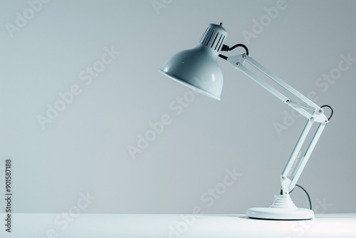 White desk lamp with adjustable arm and a lightbulb on a white table.