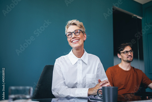 Successful business professional sitting in a boardroom, having a meeting with her team