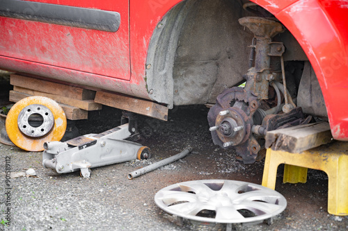 Car Repair in Progress with Missing Wheel and Tools photo