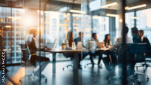 Blurred business team having an office meeting, sitting around the table and discussing business ideas together in conference room with glass walls.