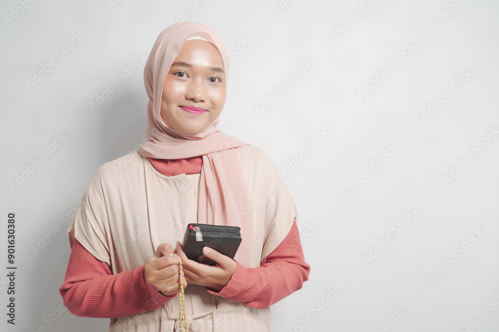 A Young Woman in a Hijab Holding a Quran and Prayer Beads