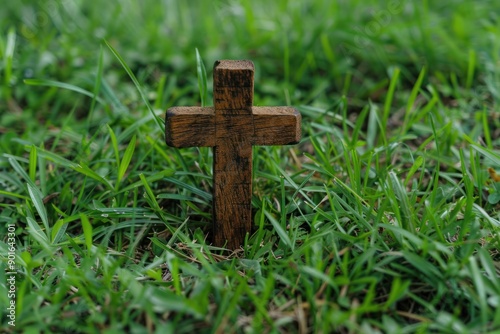 Small wooden cross on green grass lawn, pet's grave