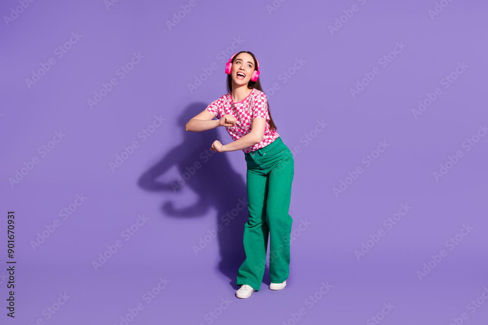 Fototapeta premium Full length photo of lovely young lady headphones dance have fun dressed stylish pink garment isolated on violet color background