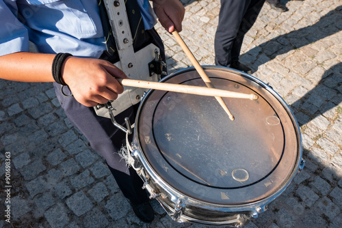 Batendo o ritmo: Musico a tocar numa tarola numa banda musical em meio a uma procissão numa festa popular photo