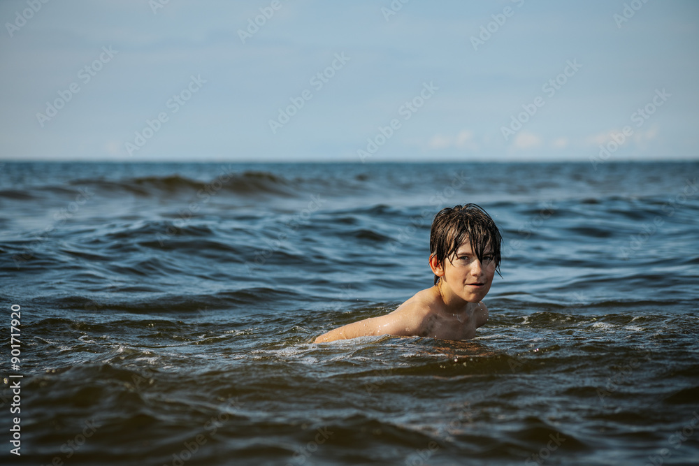A young child struggling and shouting in the water, appearing to be in distress, with splashes around him and a vast expanse of water in the background. The scene evokes a sense of urgency and concern A young child struggling and shouting in the water, appearing to be in distress, with splashes around him and a vast expanse of water in the background. The scene evokes a sense of urgency and concern