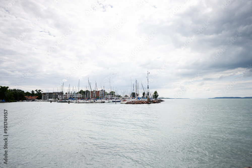 Fototapeta premium Scenic view of sailboats docked at a marina on a cloudy day in Siofok, Balaton lake, Hungary.