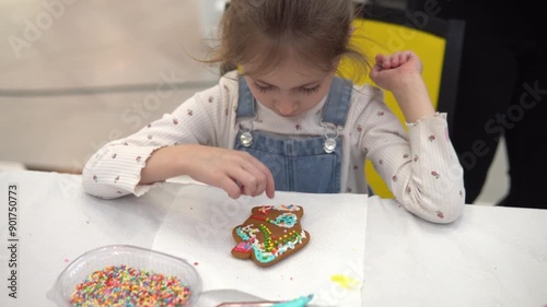 A Child Joyfully Decorating a Gingerbread Cookie with Colorful Sprinkles and Icing
