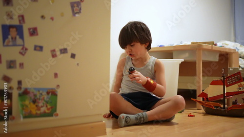 Boy playing on the floor with toys, deeply engaged in imaginative play, surrounded by a cozy room with colorful toys