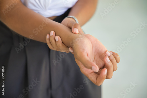 Hand closeup shot of young African woman suffering from CTS or carpal tunnel syndrome, trigger finger, gout disease, gouty wrist arthritis inflammation, wrist pain office syndrome
