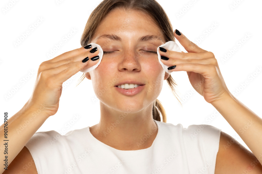 Portrait of a young smiling woman removing her make-up on a white background Portrait of a young smiling woman removing her make-up on a white background