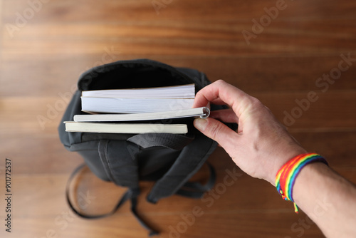 Inclusive school concept, hand holding book gay flag