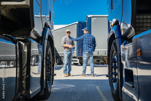 Two Truck Drivers Discuss Logistics in a Transport Yard on a Clear Day photo