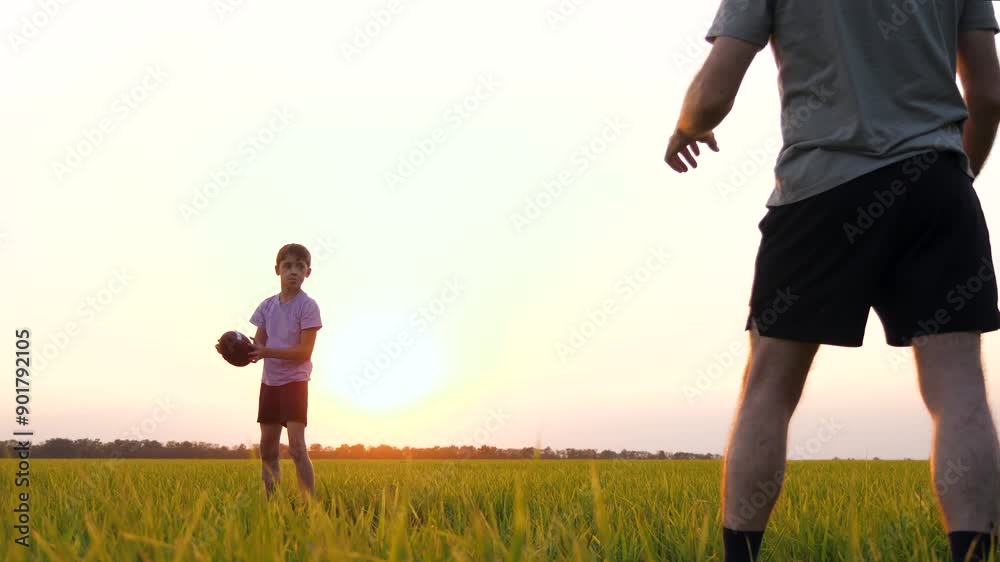 Happy family playing ball outdoors. game father and son in American football. child son throws the ball to his father. family time Happy family playing ball outdoors. game father and son in American football. child son throws the ball to his father. family time