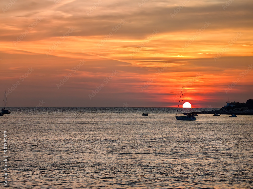 Beautiful sailboat on a tranquil Adriatic sea in Pula, Croatia in the evening sunset Beautiful sailboat on a tranquil Adriatic sea in Pula, Croatia in the evening sunset