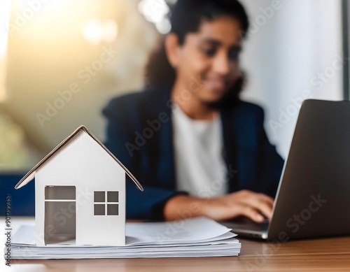 Realtor working on a laptop with a house