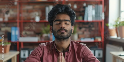 A person sits at a table with their eyes closed, focused on their meditation practice