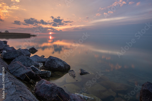 Water landscape taken from the shore of a calm lake. View over the reflecting water to the horizon in the sunset. Siofok harbor, Balaton, Hungary photo