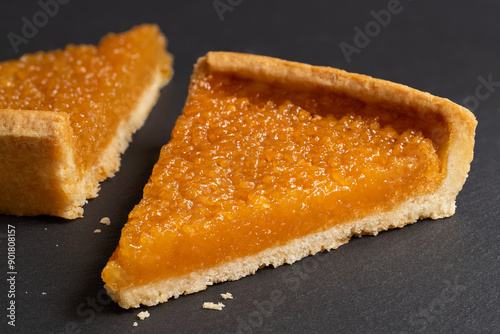 Two portions of treacle tart on black slate. photo