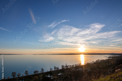 View from a hill over a lake in the evening. Beautiful landscape shot in nature. Romantic sunset in Balatonakarattya, Balaton, Hungary photo