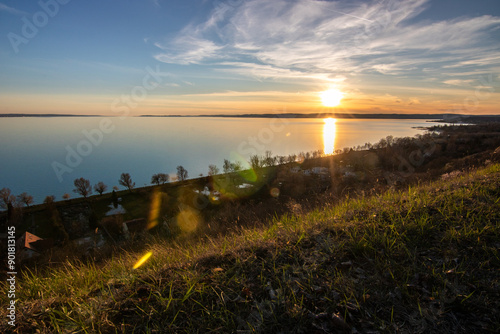 View from a hill over a lake in the evening. Beautiful landscape shot in nature. Romantic sunset in Balatonakarattya, Balaton, Hungary photo