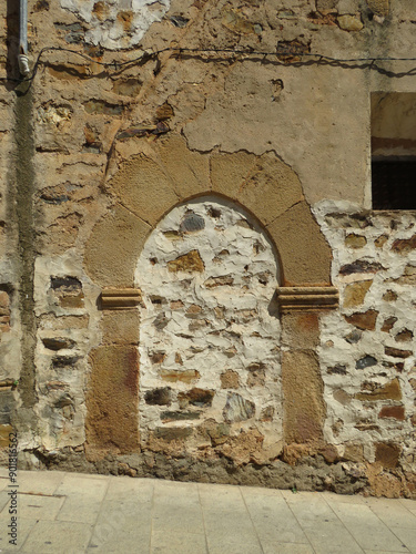 Ancient arched walled up door in the historic monumental city center of Caceres. Spain.