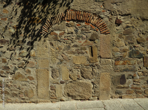 Ancient arched walled up door in the historic monumental city center of Caceres. Spain.