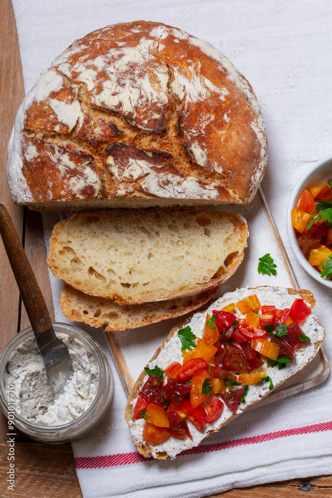 Bruschetta from homemade bread with cottage cheese and sprat pate and tomatoes on a wooden background. Rustic style.