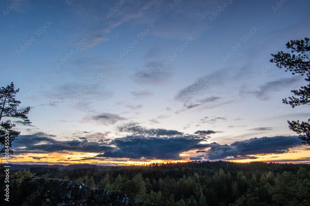 Landscape shot in a pine forest. View from a rock overlooking the trees. romantic sunset on the horizon in the evening in Amal, Sweden, Landscape shot in a pine forest. View from a rock overlooking the trees. romantic sunset on the horizon in the evening in Amal, Sweden,