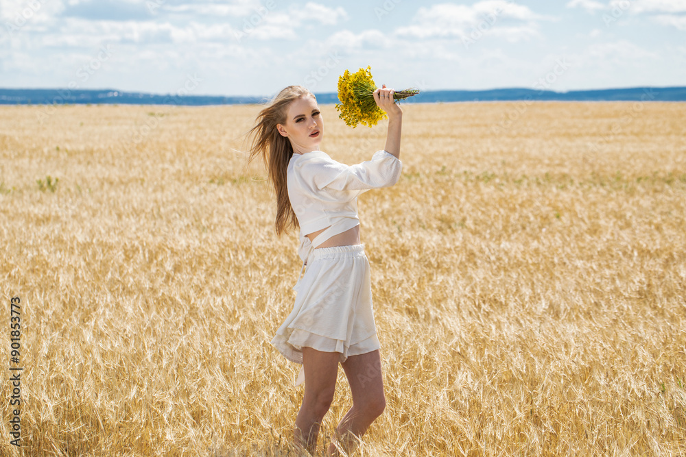 Young beautiful blonde girl posing in a wheat field Young beautiful blonde girl posing in a wheat field