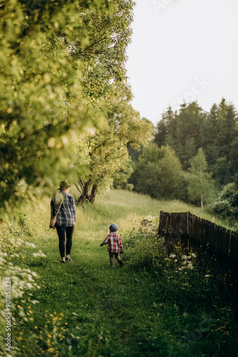 Summer trip with children to the mountains. Evening walk of a mother with a child in an alpine village in summer.