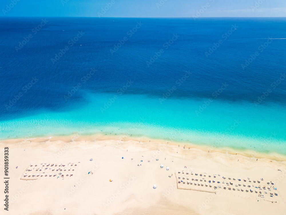 Obraz premium White sandy beach and blue water in Morro Jable, south of Fuerteventura, Canary islands