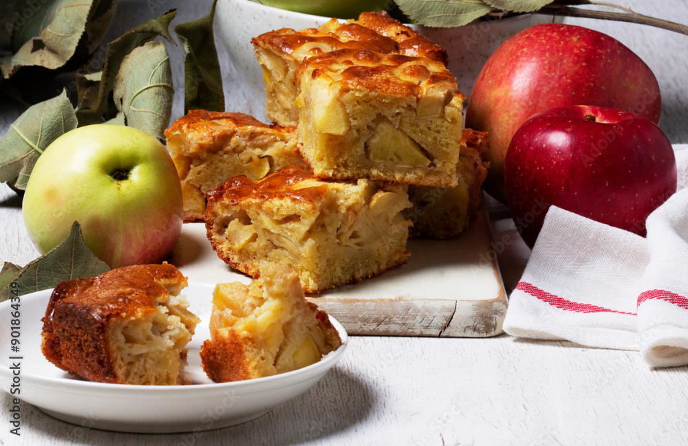 Apple pie, apples and teapot served for tea. Traditional apple dessert.