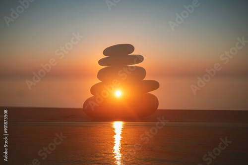 Pyramid of stones against the background of sunset or sunrise on the sea, artistic creative technique in photography multiple exposure, double exposure photo